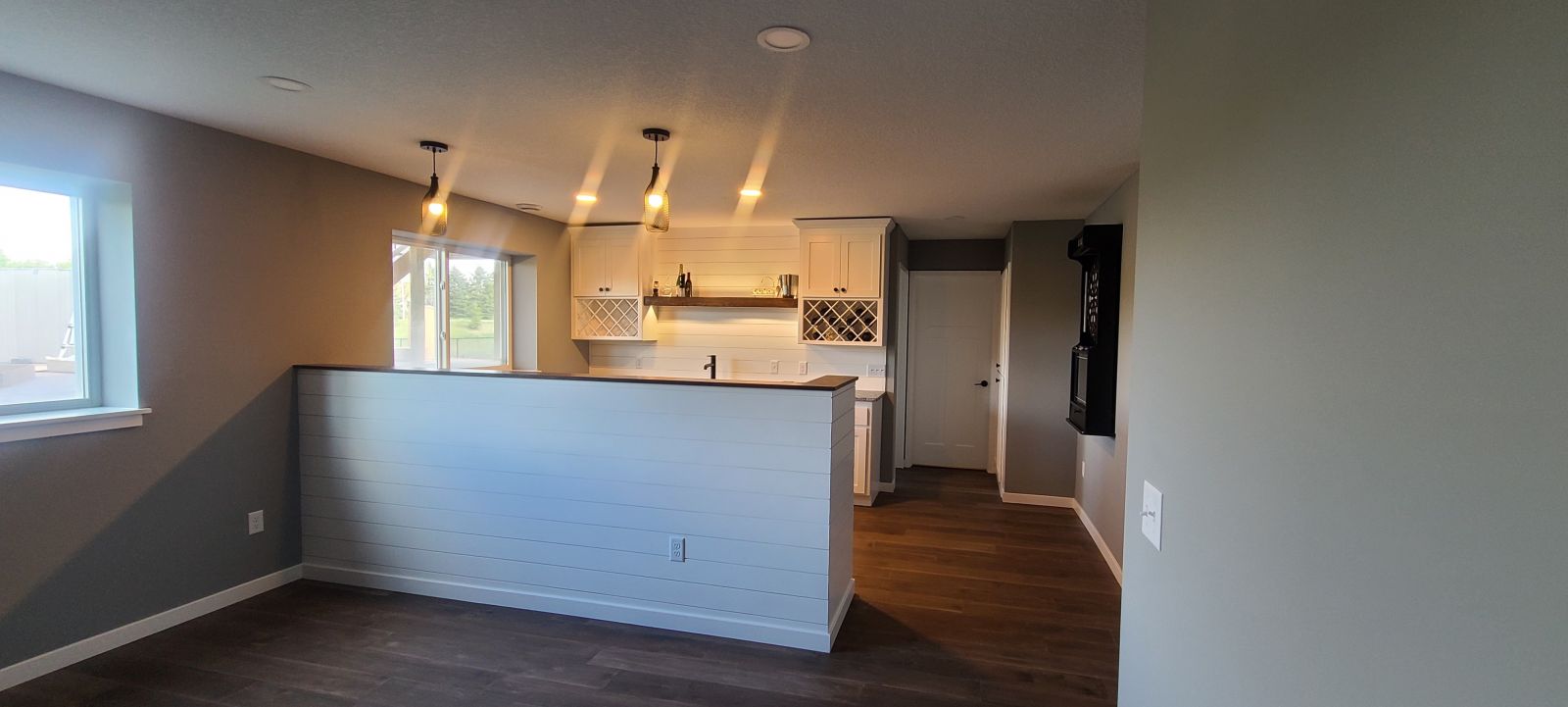 Finished basement with an open living area, custom wet bar and recessed lighting