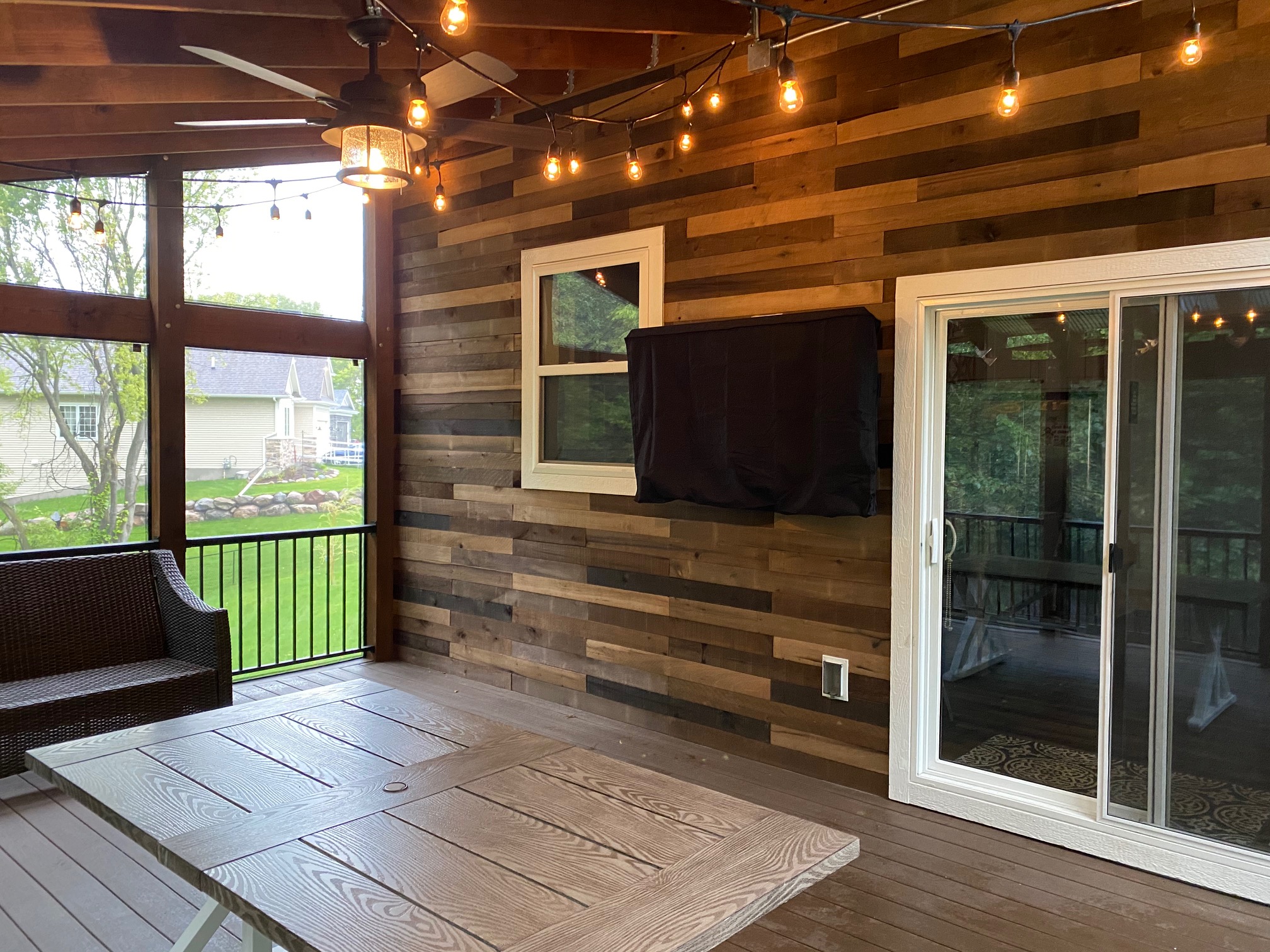 Finished screened porch with wood accent wall, lighting and durable flooring